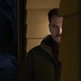 a man peering around the corner of a house