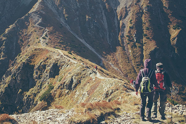 a couple hiking a mountainous ridge