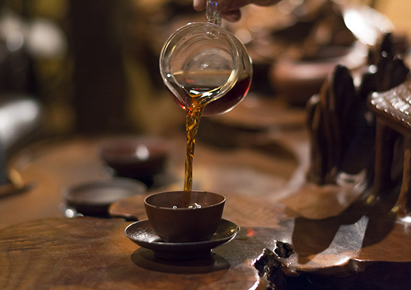 a hand pouring tea into a cup
