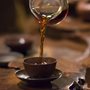 a hand pouring tea in a cup