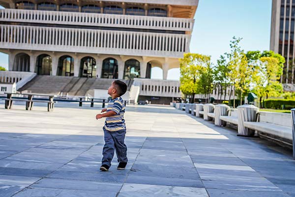 a boy walking through an outdoor plaza