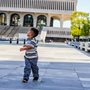 a boy walking through an outdoor plaza