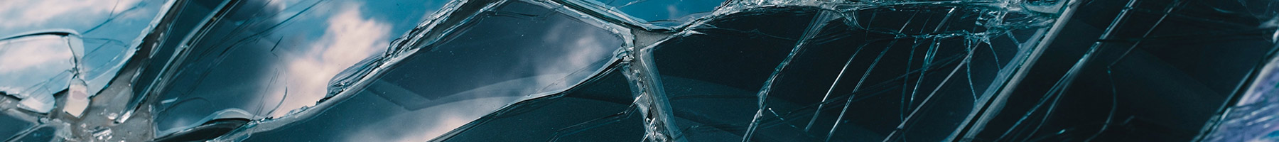 sky and clouds reflected in broken glass