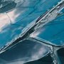 clouds and sky reflected in a a broken glass window