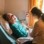 caregiver at the bedside of a sickly woman