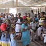 people singing and praying in a small rough church in Haiti