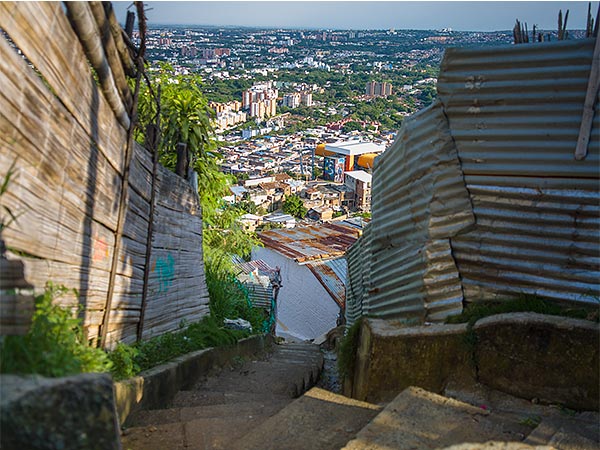 Vista de Cali desde el punto alto de unas escaleras, lindadas de barreras de chapa.