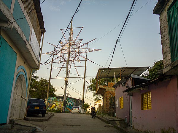 Metal frame star with lights above tank at top of a street