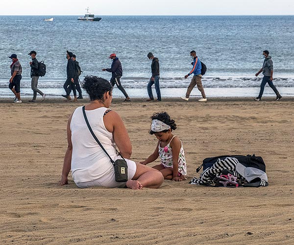 Migrants from Morocco walk along the shore escorted by Spanish Police after arriving at the coast of the Canary Island, Spain.