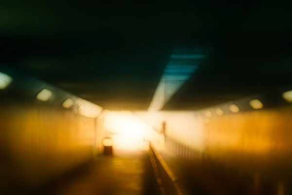 blurry impressionistic photo of light at the end of a dark tunnel