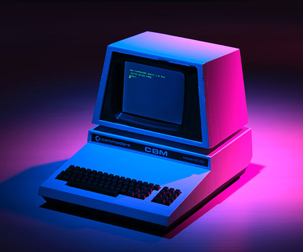 an old Commodore computer in pink and blue lighting