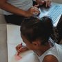 a little girl coloring a heart on a piece of paper