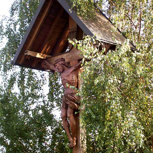 carved wooden crucifix in a grove of birch trees