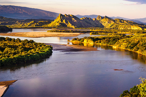 Paisaje con montañas y río a la luz del sol