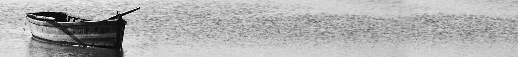 black and white photo of a rowboat in still water