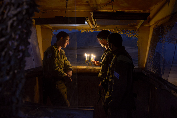 soldiers lighting a menorah