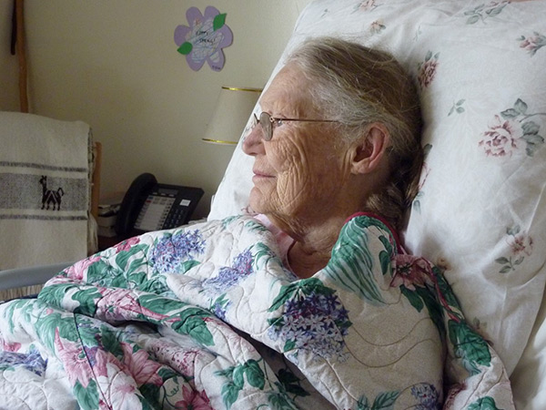 An elderly woman looking out a window