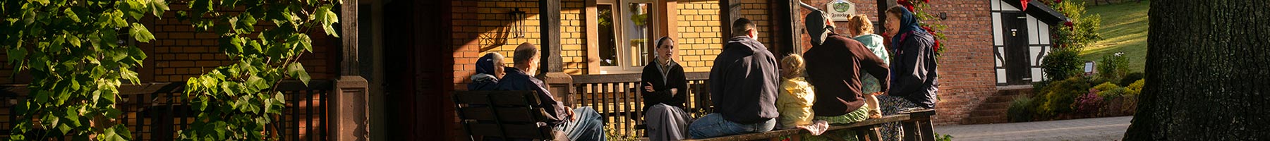 community members sitting together outside their house