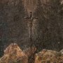 painting of a crucifix in the woods