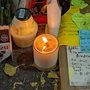 candle burning in a jar among notes and flower petals