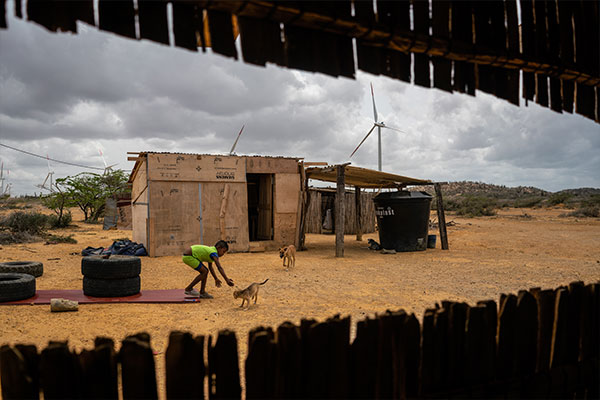 Wayuu boy playing with wind mills in the background