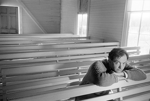 Rich Mullins in a church pew looking up