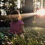 little girl in a sunny field of daisies