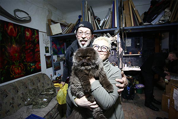 older couple and their cat in a basement room