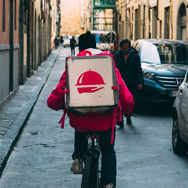 Uber Eats delivery guy biking down a busy street