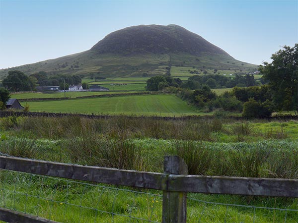 green hill against a blue sky