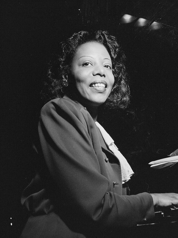 Mary Lou Williams posing at a piano