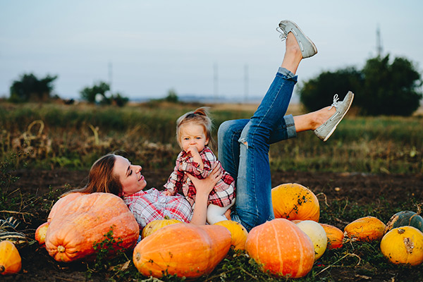 A woman and her daughter in a pumpkin patch