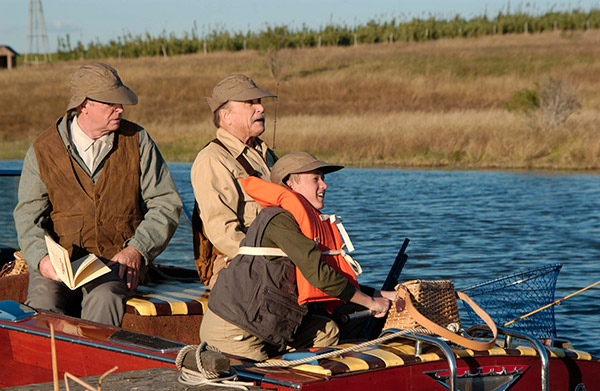 a young boy fishing with two old men