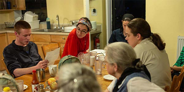 people reading poetry around a dinner table