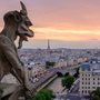 a stone sculpture gargoyle looking over a city