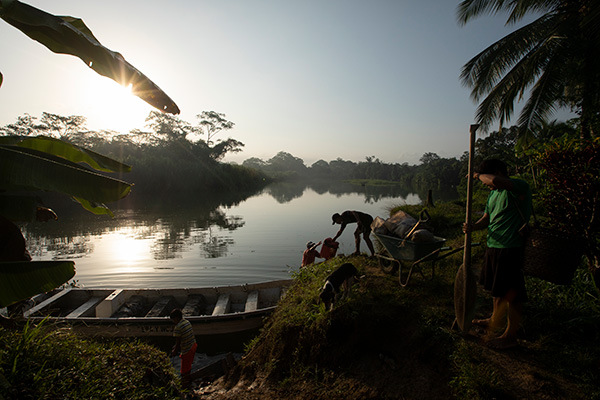 men standing near a boat at a river's edge