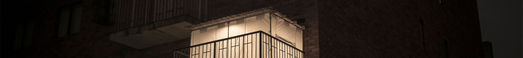 a Sukkah on a city balcony at night