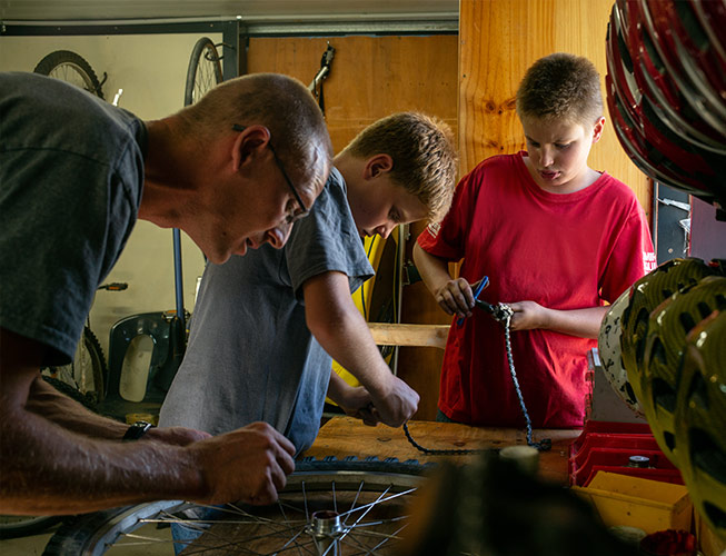 Man and boys repairing bicycles