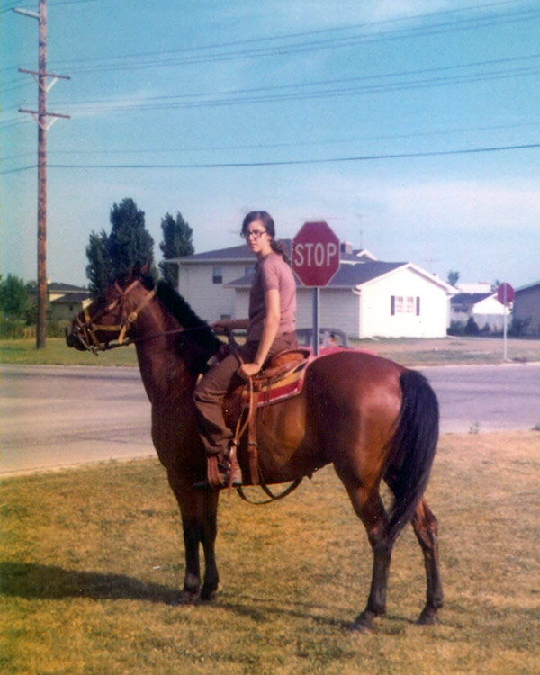 a young woman riding a chestnut horse