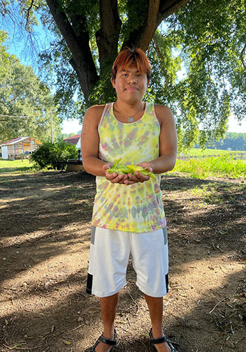 a young man holding peppers