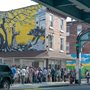 people standing outside a soup kitchen to receive food