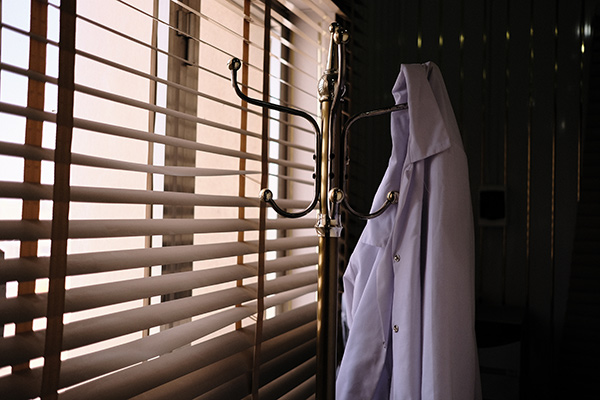 a lab coat hanging by a window