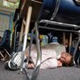 a girl curls up under her desk during a lockdown drill