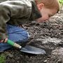 a boy holding a trowel in a garden