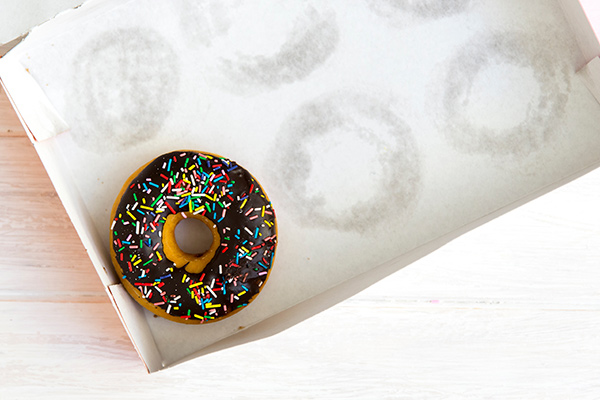 a chocolate and sprinkle covered donut in a box