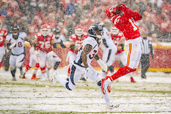 A football player makes a catch on a snowy field