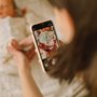 Mother taking photo of baby boy on mobile phone