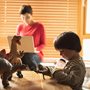 Boy playing with toys while mother uses laptop