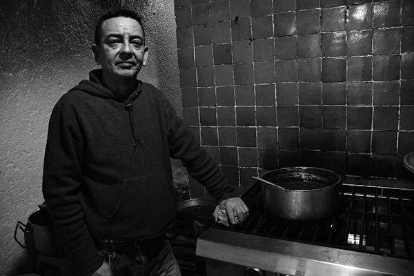 a man standing by a stove 