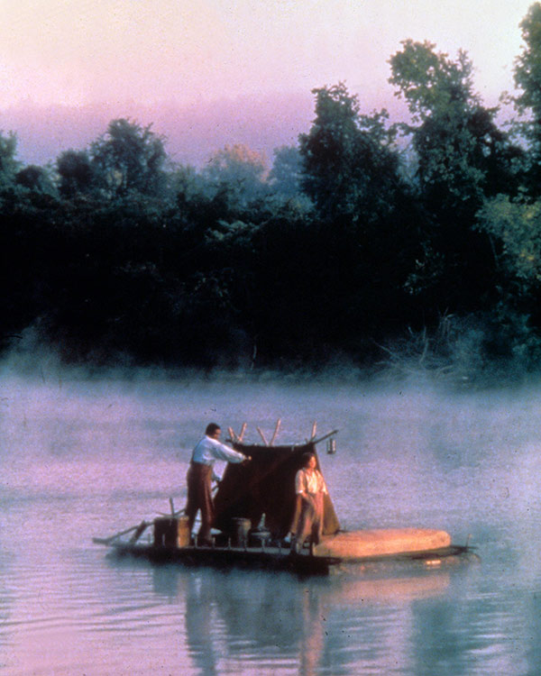 two people on a raft floating on a river
